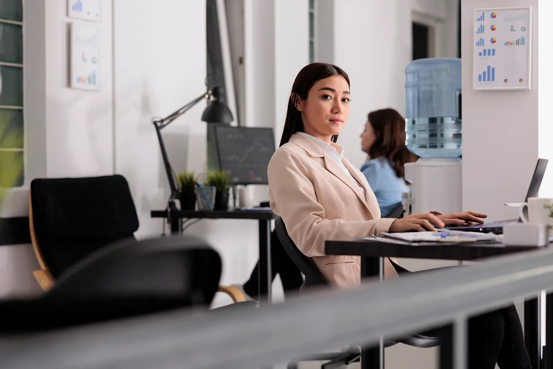 A professional at a desk in a bright, calm workspace at Grand Water Offices.