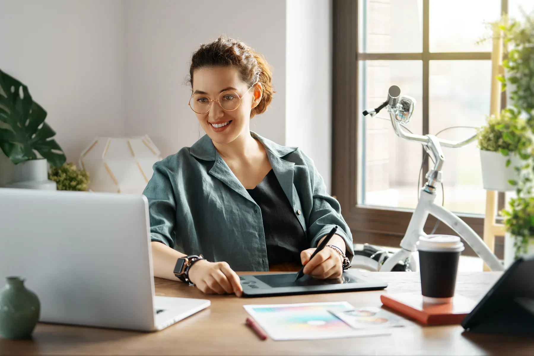 A creative professional at work in a warm, light-filled Grand Water Offices workspace.