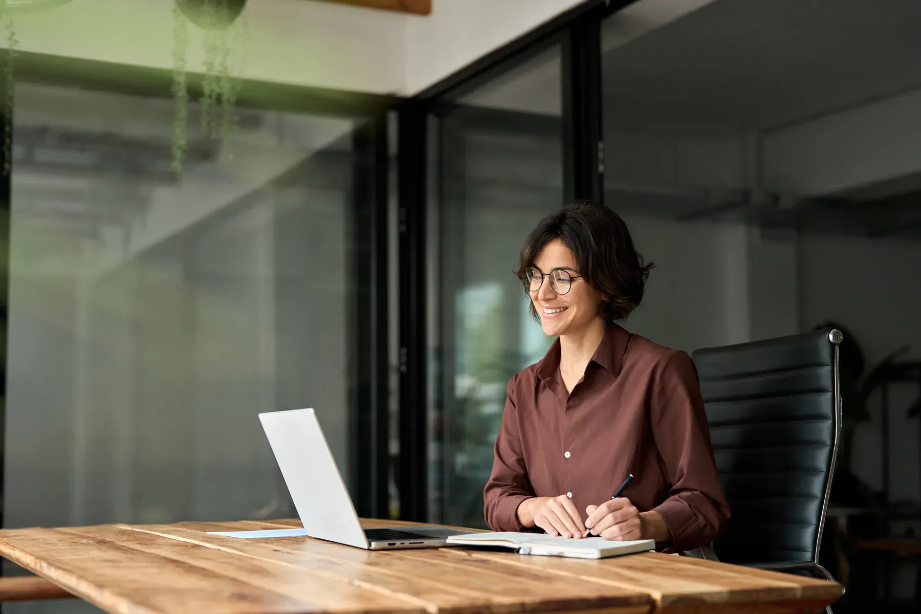 A member working at the desk of a private executive suite at Grand Water Offices, in warm natural light.