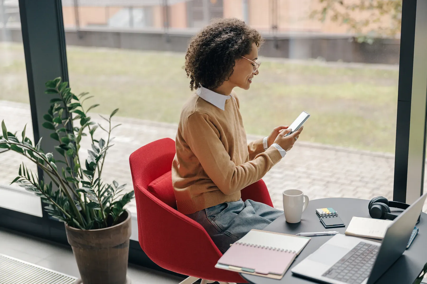 A professional taking a call by a sunlit window — the address and reception a virtual office provides.